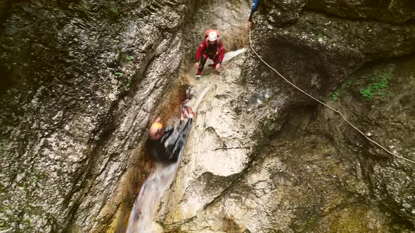 Aerial view of man throwing himself through a sliding rock at Soca river.