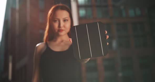 Woman holding a solar cell in front of the camera