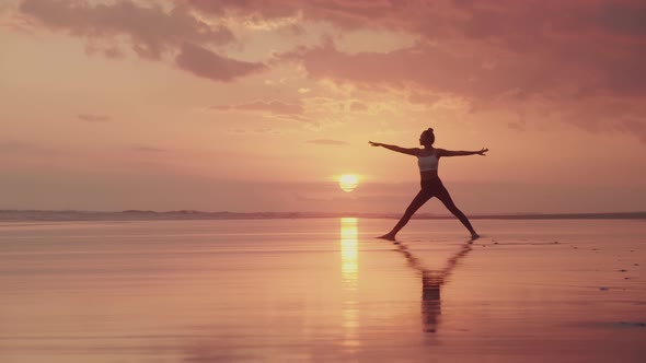 Female Silhouette Stretching at Sunset