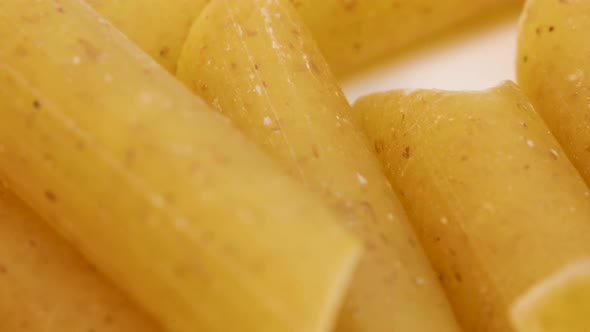 Very close shot of wheat pasta, italian macaroni, macro shot in 4k. Rotating motion, view from above