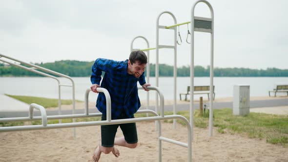 Young Strong Man Exercising on the Beach