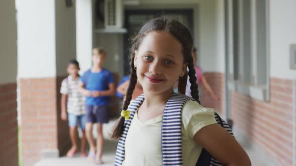 Video of happy caucasian girl standing at school corridor