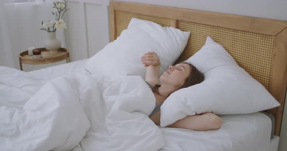 Smiling Woman Waking Up. Teen Hispanic Woman Wakes Up at Home. Young Girl Stretching After Awake