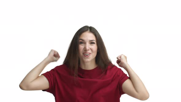 Attractive Young Woman in Red Tshirt Winning Saying Hooray and Jumping From Happiness Cheering and