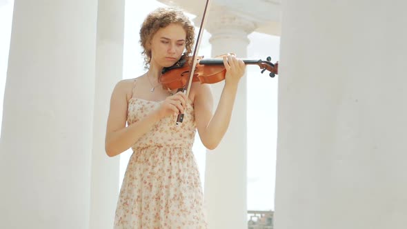 young curly blond woman the violinist: Musician playing violin