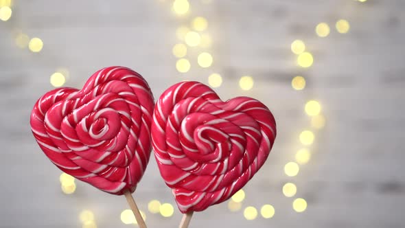 Two Heartshaped Candies Move Against the Background of Lights