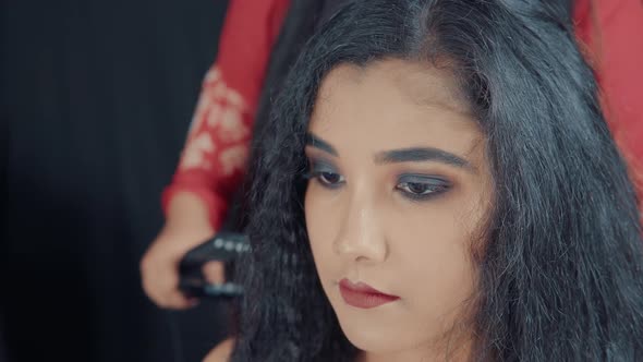 Close up of beautiful woman with make up and hairdresser making her  a hairstyle