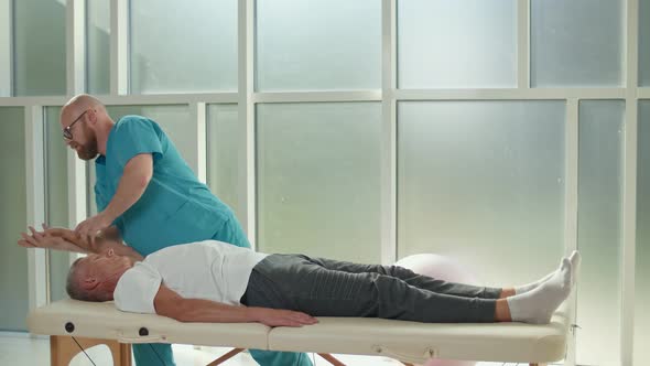 Physiotherapist Conducting a Therapy Session With an Older Man in a Rehabilitation Center