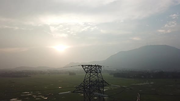 Aerial view electric tower with background hill at paddy field