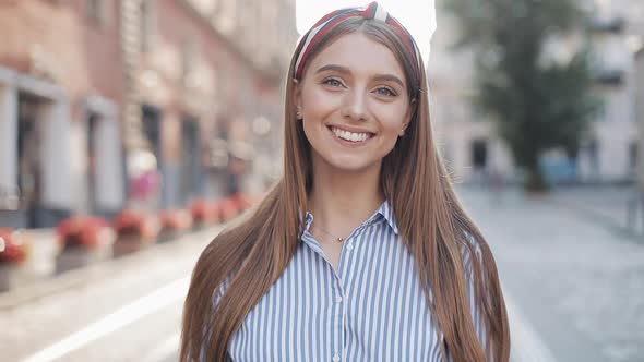 Portrait of Young Happy Attractive Girl with Straight Brown Hair and Blue Eyes Wearing in Striped