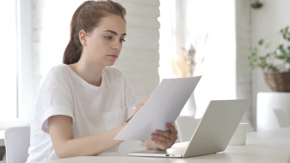 Young Woman Reading Documents Paperwork
