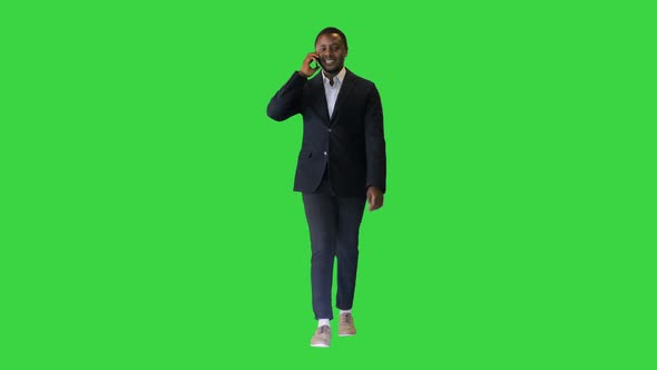 Young Black Businessman Walking and Talking on the Phone on a Green Screen Chroma Key