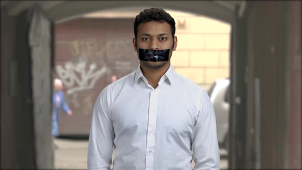 Portrait of Male Protester with Black Tape Over Mouth
