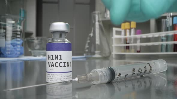 H1N1 vaccine vial in medical lab with syringe placed