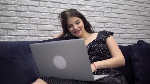 Attractive Woman Watching at Laptop Screen Lauching Movie Films Relaxing at Home