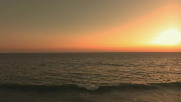 Drone shot of foaming waves, ocean surface and horizon at El Matador Beach, Malibu, Califronia, USA