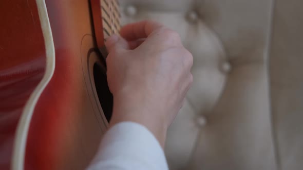 Hands on guitar strings.