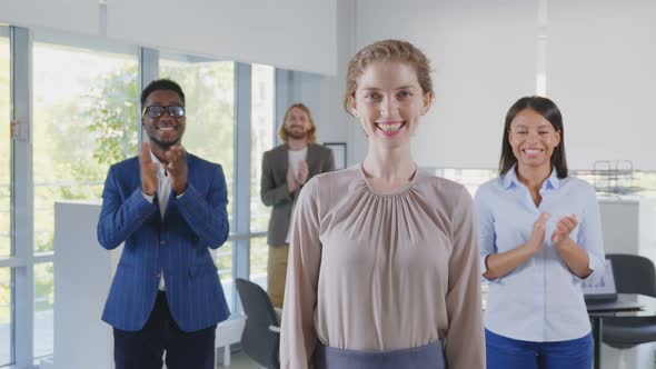 Portrait of Multicultural Business Team Applauding to Young Female Leader in Office