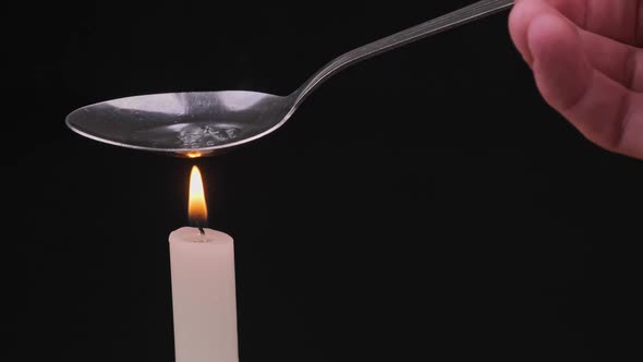 Cooking Drugs in a Spoon on a Candle Flame