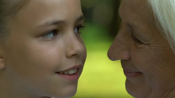 Granny and Granddaughter Looking at Each Other, Posing for Camera, Close Up