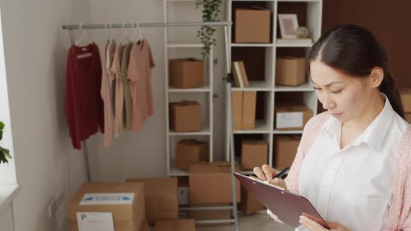 Woman Writing Notes on Clipboard