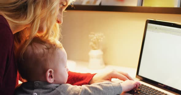 Mother and baby using laptop 4k