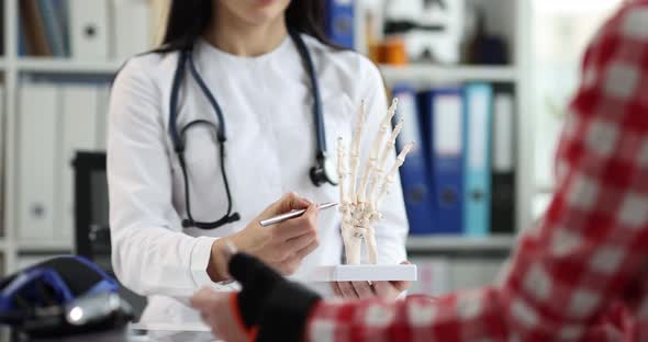 Doctor Shows Bone Damage in Patient on Model of Hands Closeup