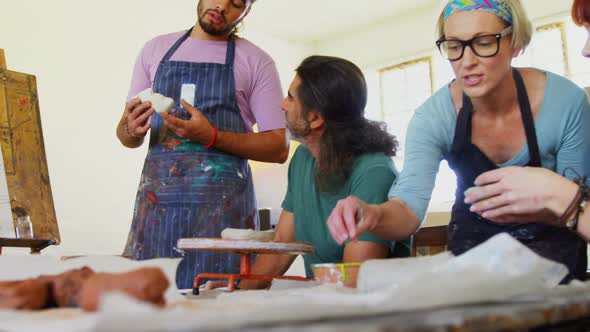 Drawing teacher assisting artist in pottery 4k