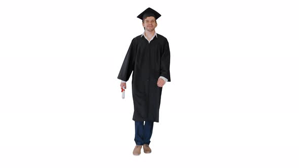 Smiling Male Student in Graduation Robe Walking with His Diploma on White Background.