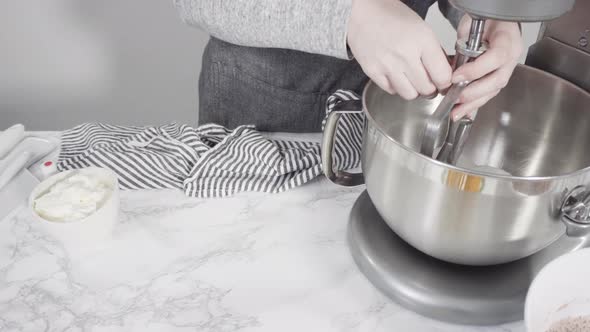 Step by step. Mixing ingredients in a standing kitchen mixer to bake red velvet cupcakes.