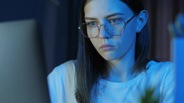 Portrait of Teenage Girl with Glasses Looks at the Monitor