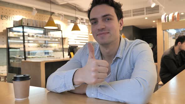 Thumbs Up By Young Man in Cafe