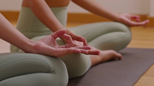 Close up hand of young woman sit on yoga mat breathing with yoga lotus pose.Yoga meditation of young