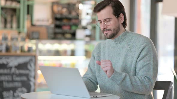 Young Man Having Wrist Pain While Typing Laptop