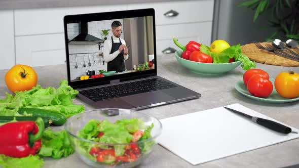 Laptop Computer with Man Food Blogger Shows Slice Cucumber Tells Teaches Student