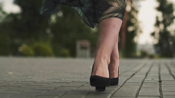 Woman in Stylish Shoes and Skirt Walks Along Paved Road