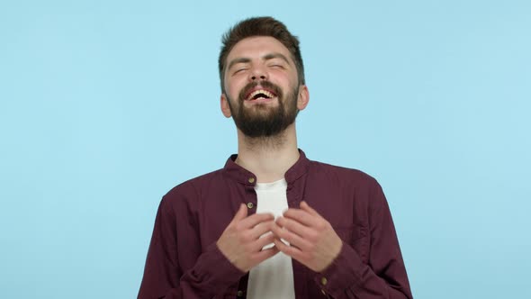 Carefree Young Man with Beard Wearing Casual Red Shirt and Tshirt Laughing Out Loud and Smiling