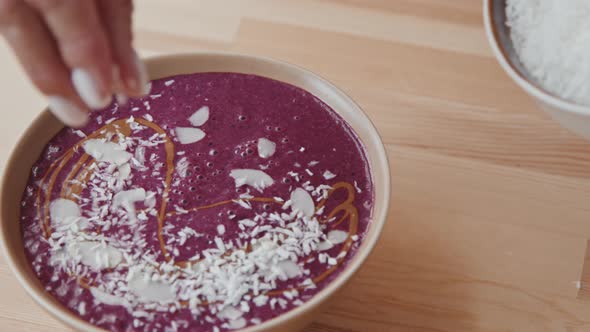 Unrecognizable Woman Adding Coconut to Smoothie Bowl