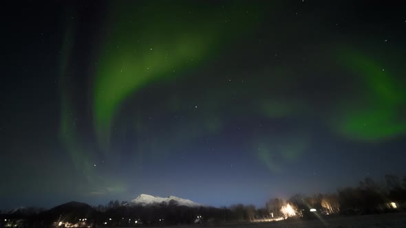 Snowy Mountains, Lights From the Cabin and Aurora Borealis in the Sky in Timelapse