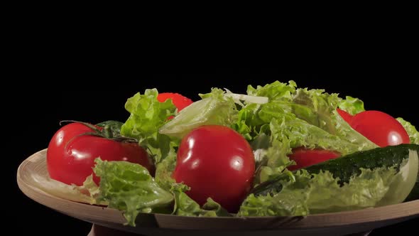 Fresh Tomatoes Cucumbers and Lettuce are Placed on a Wooden Plate on a Black Background Water Drops