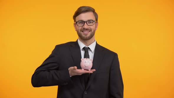 Man Putting Coin in Piggy-Bank, Family Budget Planning, Savings and Finance