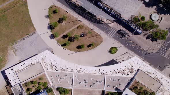 Aerial shot following a bike on the street while a tram stops at the tram stop.