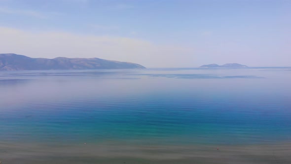 Ocean beach sunsets beautiful sky Aerial view drone camera. Island on horizon. Albania