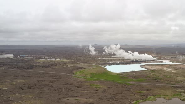 Steam Rising From Hot Springs On A Cloudy Day. Geothermal Landscape In Iceland. wide aerial