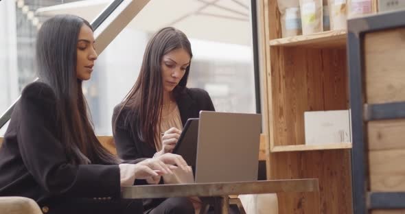 Two Women Sitting and Working in a Modern and Industrial Style Cafe