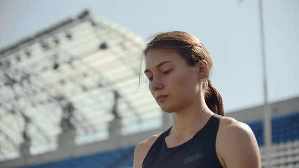 Beautiful Woman Athlete at the Stadium Breathing and Preparing To Start the Race. Motivation and