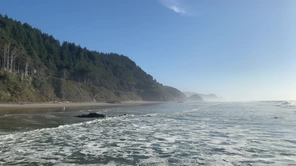 Oregon Coast With Ocean Waves Coming Into The Beach With Misty Background. - wide shot