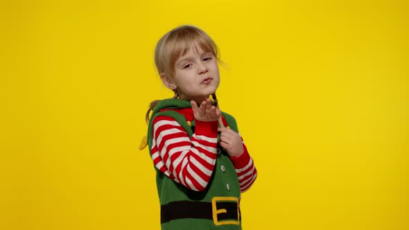 Shy Shamed Child Girl Christmas Elf Santa Helper Costume Posing Looking Camera Blows Air Kiss