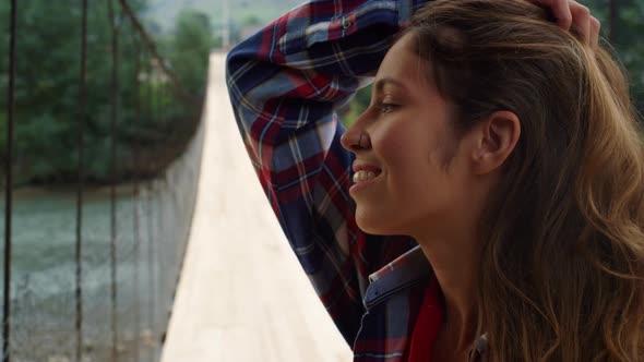 Beautiful Woman Touch Hair on Nature River Bridge