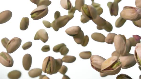 Closeup of Delicious Salted Pistachios Falling Diagonally on a White Background